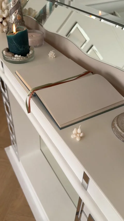Vertical 4K - Burning Candle And Open Journal On White Fireplace Mantel Decor Stock Footage 345346562