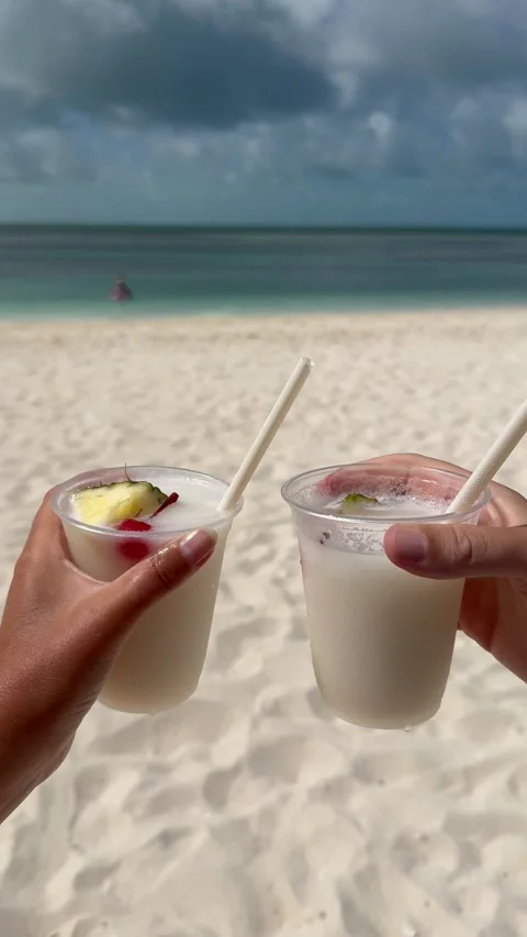 Vertical 4K Close Up Of Couple Holding Two Pina Colada Cocktails At Beach Stock Footage 335549143