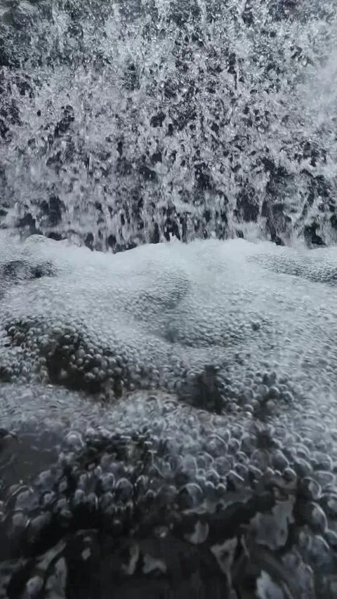 Vertical 4K Close Up of Foamy Waterfall Splashing Over River Rocks Stock Footage 337158160