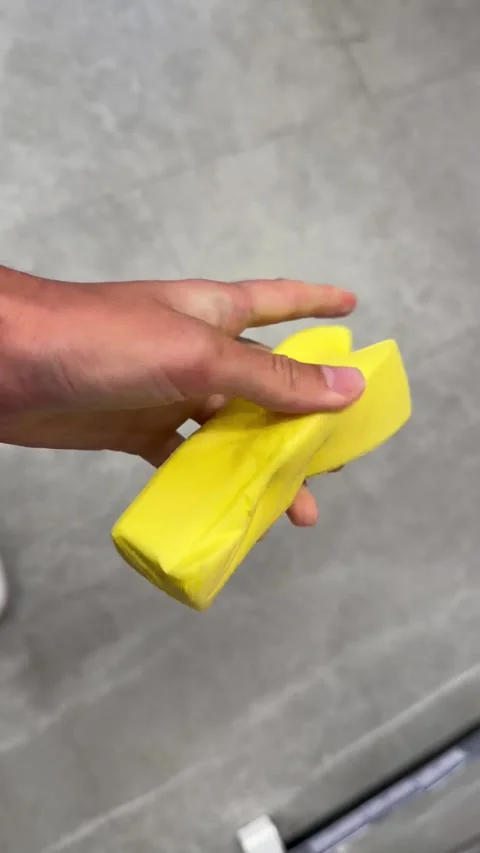 Vertical 4K close-up of a hand squeezing a viral butter squishy toy Stock Footage 342061478