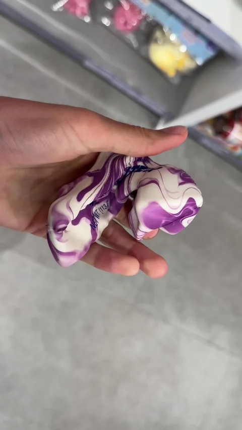 Vertical 4K close-up of a hand squeezing a trendy butter squishy toy Stock Footage 342061480