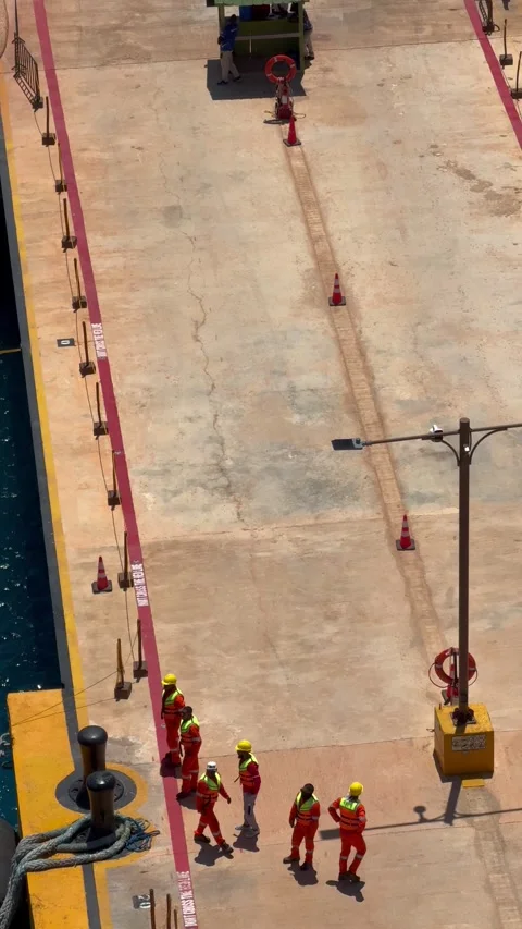 Vertical 4K Close Up High Angle Of Port Crew Handling Cruise Mooring Line Stock Footage 335480031