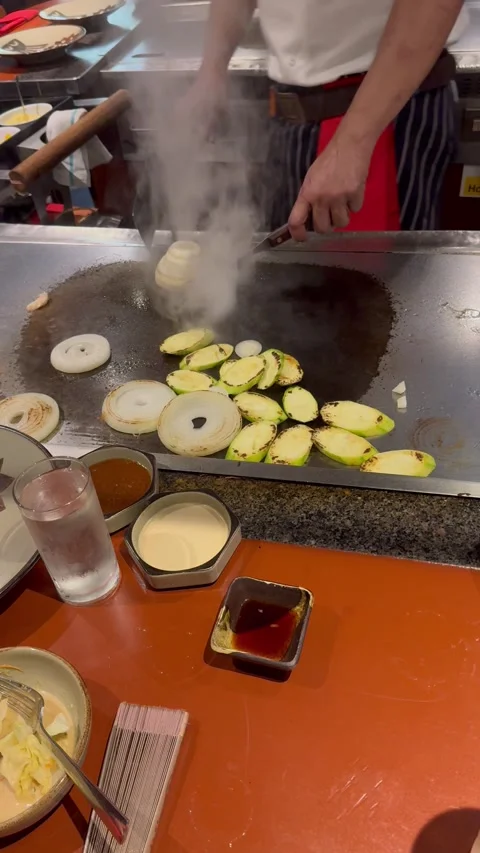 Vertical 4K Close Up Teppanyaki Chef Making Smoking Onion Choo Choo Train Trick Stock Footage 335654580