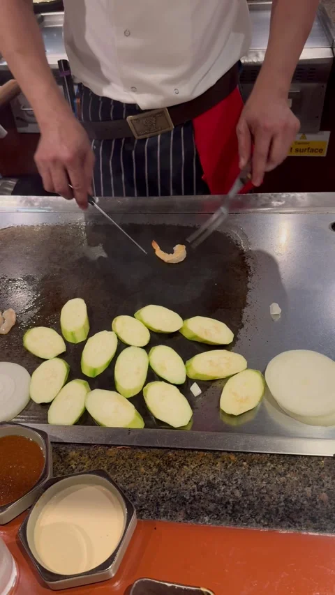 Vertical 4K Close Up Teppanyaki Chef Playing With Shrimp Using Fork And Knife Stock Footage 335654669
