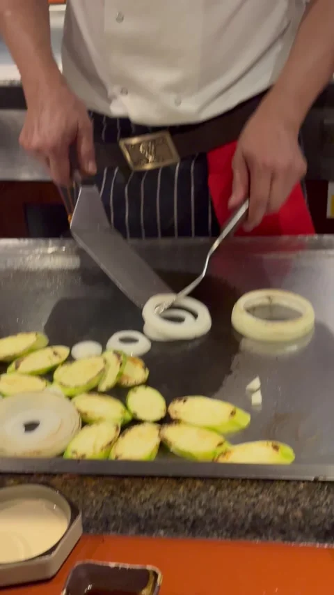 Vertical 4K Close Up Of Teppanyaki Chef Building And Lighting Onion Volcano Stock Footage 335654680