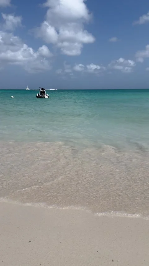 Vertical 4K Cloud Shadow Passing Over Turquoise Aruba Sea With Boats And Jet Ski Stock Footage 335372658