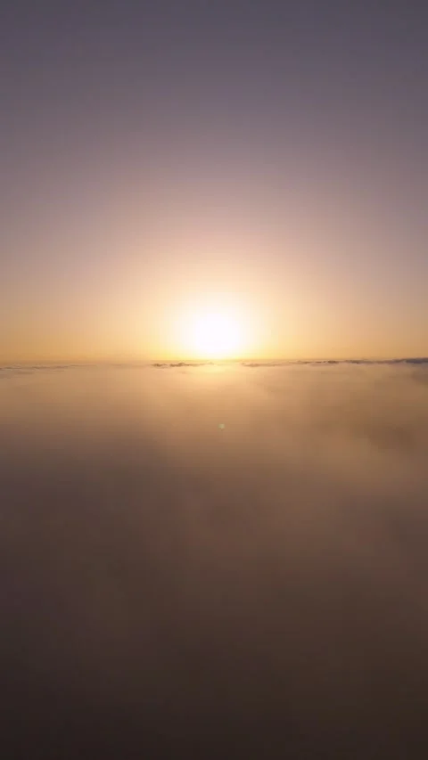 Vertical 4K Drone Flight Above Clouds at Sunset – Sun in Frame Stock Footage 314600575