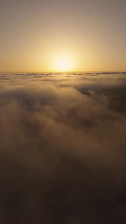 Vertical 4K Drone Flight Above Clouds at Sunset – Sun in Frame – Relaxing 動画素材 314600622