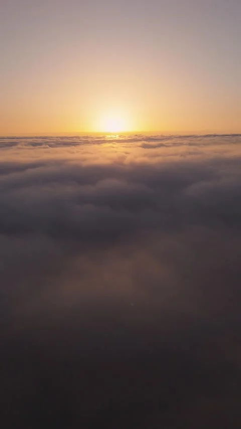 Vertical 4K Drone Flight Above Clouds at Sunset – Sun in Frame – Relaxing Stock Footage 314600626