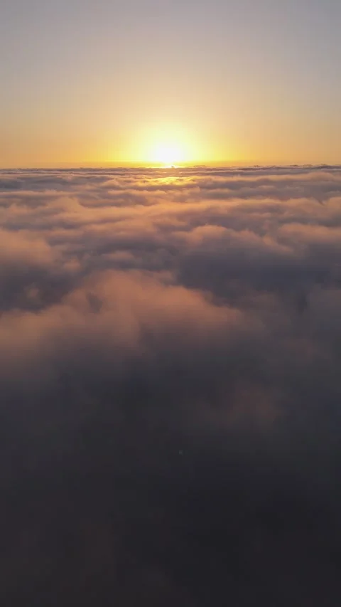 Vertical 4K Drone Flight Above Clouds at Sunset – Sun in Frame – Relaxing Stock Footage 314600657