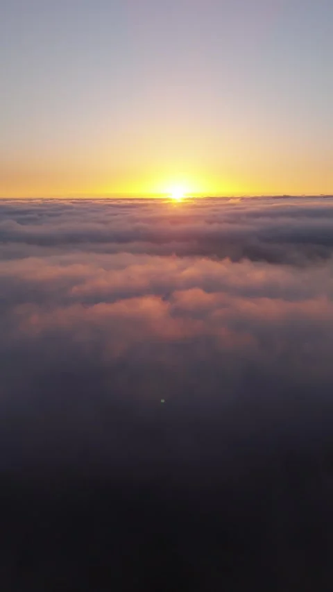 Vertical 4K Drone Flight Above Clouds at Sunset – Sun in Frame – Relaxing 動画素材 314600766