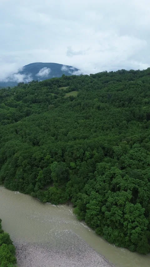Vertical 4K drone footage over the Tekhuri river and forested mountains hill Stock Footage 343675194