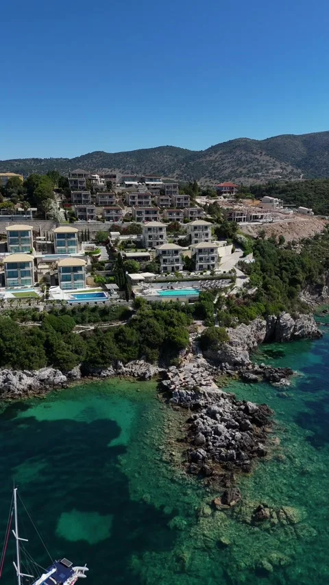 Vertical 4K drone video of luxury boutique hotel built on rocky coastal cliff in Stock Footage 340560551