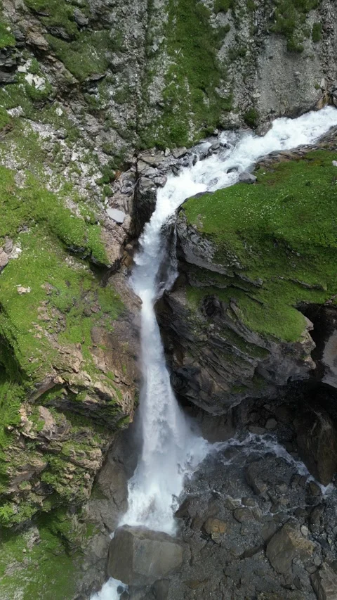Vertical 4K Drone View of an Alpine Waterfall Amid Rocky Mountain Terrain Video stock 328706126