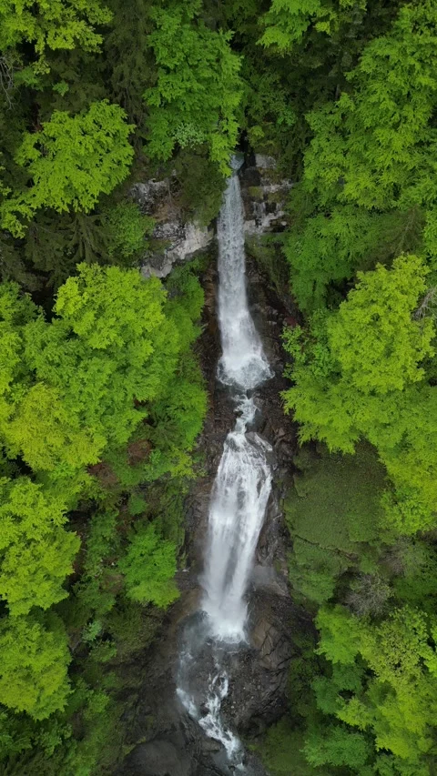 Vertical 4K Drone View of an Alpine Waterfall Amid Rocky Mountain Terrain 库存影片 328706425
