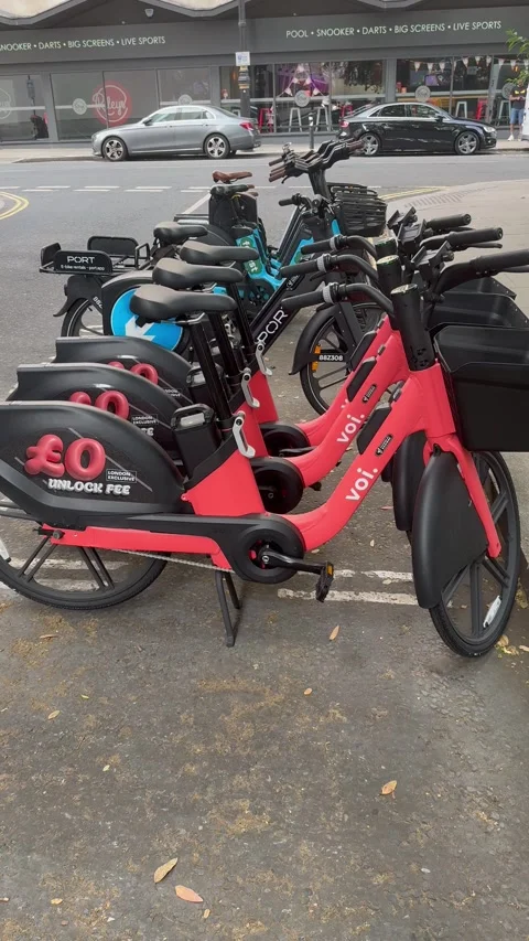 Vertical 4K Editorial Panning Shot Of Voi Rental E-Bikes Parked In London Vídeos de archivo 335831918