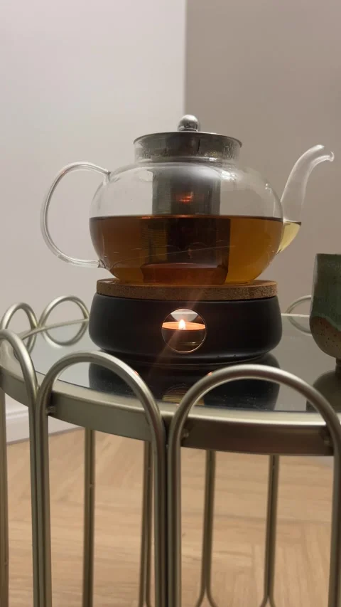 Vertical 4K - Glass Teapot With Tea Warmer Candle Flame Still Shot Hygge Stock Footage 345443501