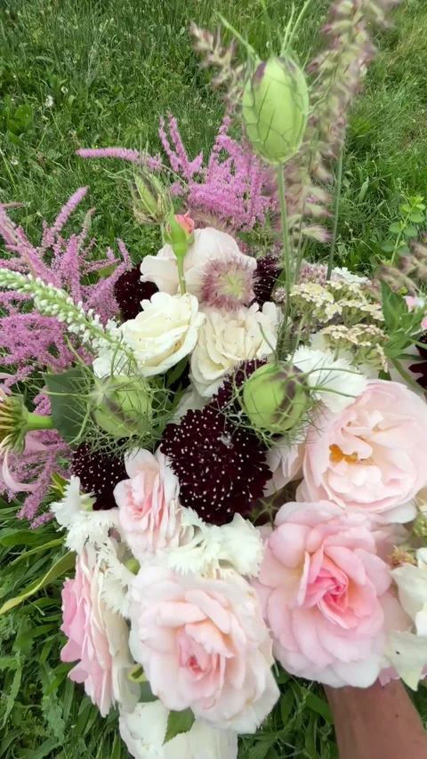 Vertical 4K handheld close up of artisan flower bouquet over grass. 스톡 동영상 337910089