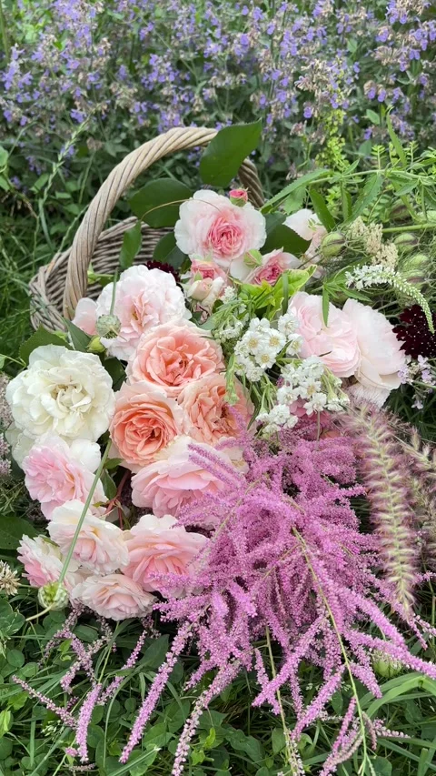 Vertical 4K handheld close up of rustic flower basket in grass. 스톡 동영상 337902284