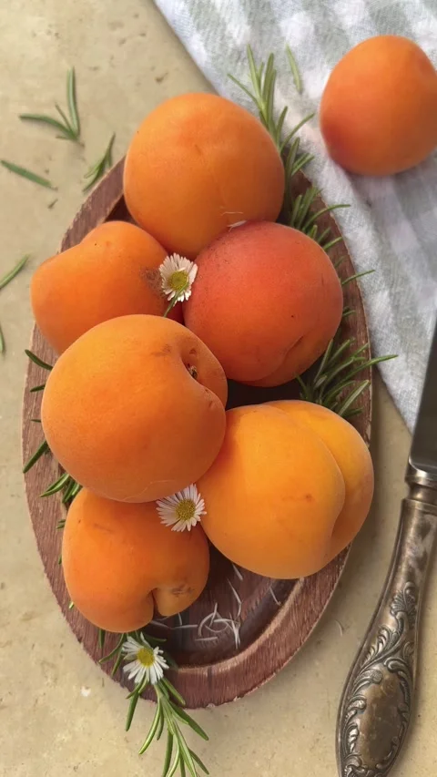 Vertical 4K handheld shot of fresh orange apricots on rustic plate. 스톡 동영상 337789213