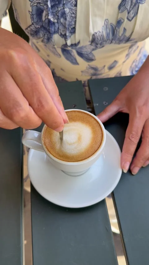 Vertical 4K High Angle Close Up Woman Hands Stirring Latte Art Coffee Vídeos de archivo 335779462