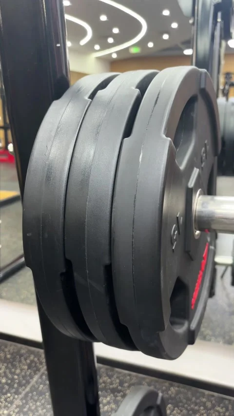 Vertical 4K Macro of Removing Heavy Weight Plate from Gym Rack Stock Footage 329336574