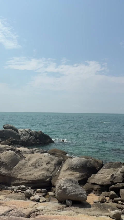 Vertical 4K Panning of Distant Vessel and Rugged Coastline Stock Footage 330986928