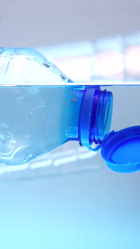 Vertical 4k, Plastic Bottle With Attached Cap Floating in Clear Water, Stock Footage 290283004