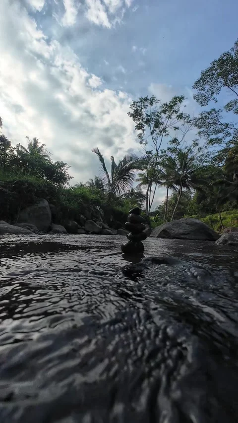 Vertical 4K River Stream with Balanced Stones and Natural Sky Reflection Stock Footage 337158048