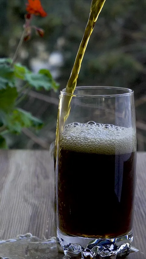 Vertical 4K Slow Motion of Cola Soda Overflowing and Spilling from Glass Видео 331313646
