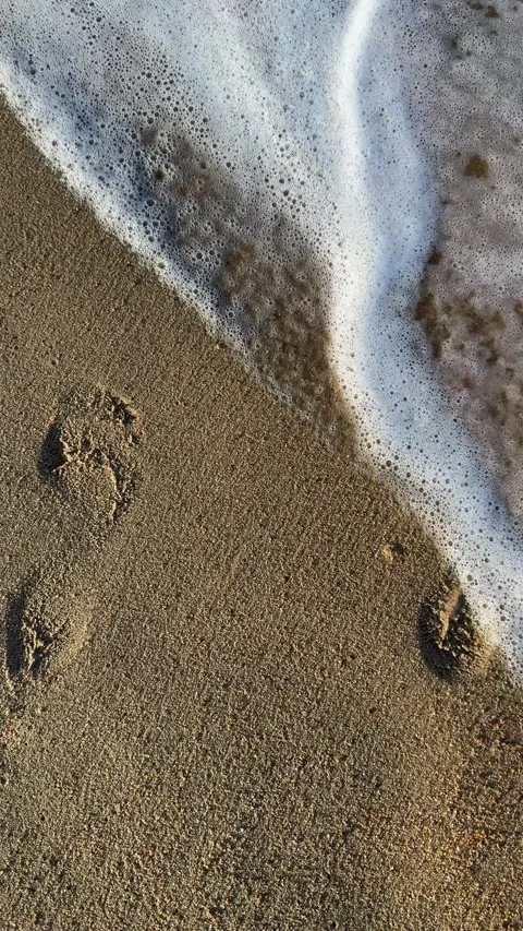 Vertical 4K Slow Motion Sea Waves Erasing Footprints on Sand Stock Footage 332041036