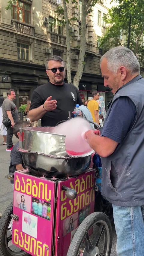 Vertical 4K street video. Back view. Man sells pink cotton candy Stock Footage 332745857