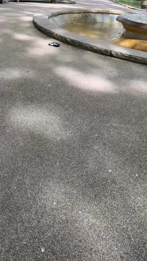 Vertical 4K Toy RC Car Driving Around Fountain And People Feet In Park Vídeos de archivo 335826896