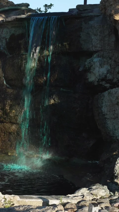 Vertical 4K video of an artificial waterfall with turquoise blue water Stock Footage 342078191