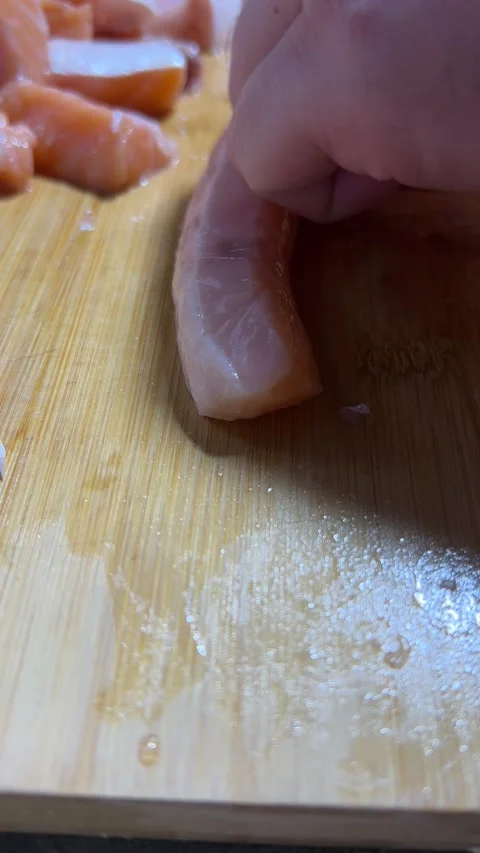 Vertical 4K video. Chef cuts salmon into pieces on wooden cutting board Stock Footage 287517485