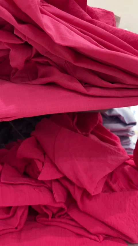 Vertical 4K video close up. Camera moves along shelf with pink clothes Stock Footage 314503424