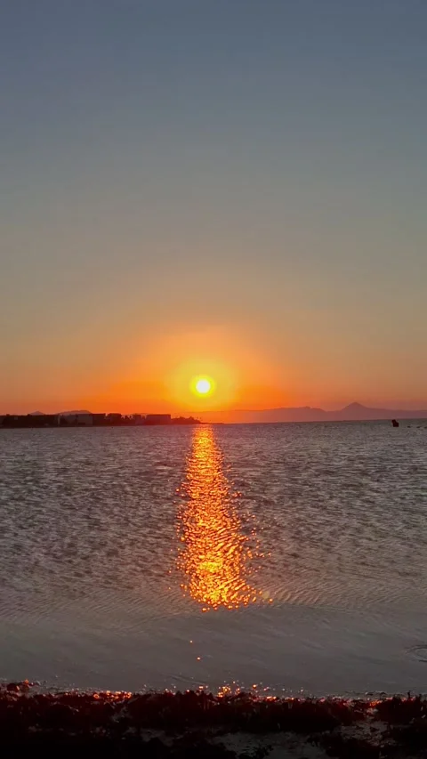 Vertical 4K video of a dramatic ocean sunset with bright orange sun dipping  Stock Footage 341775223
