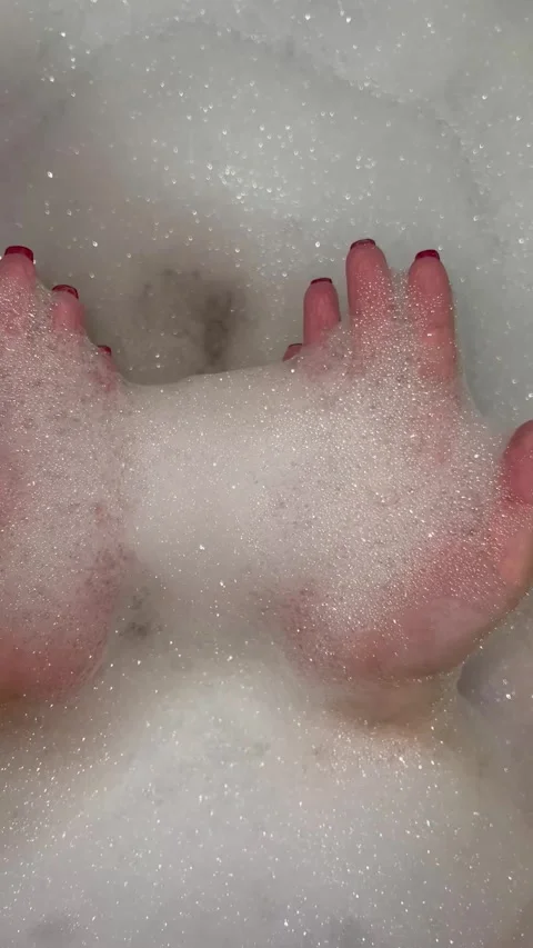 Vertical 4K video. Female hand with red manicure closeup in bath with soap foam Stock Footage 276449005