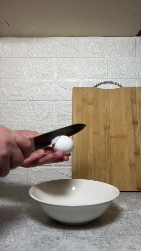 Vertical 4K video. Man with knife breaks chicken egg at kitchen Stock Footage 280880393
