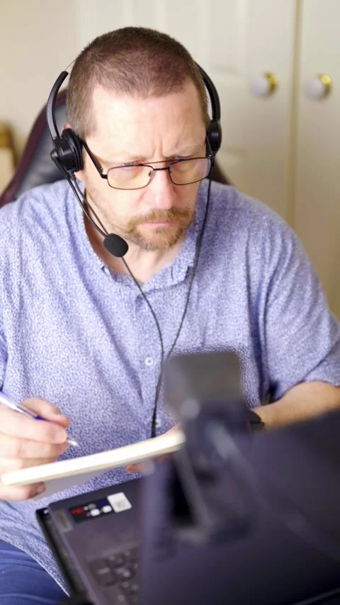 Vertical 4K video of man taking notes during online training Stock Footage 329358295