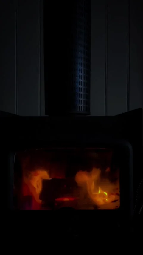 Vertical 4K video showing warm fire, sparks, and natural light from burning wood Stock Footage 330471268