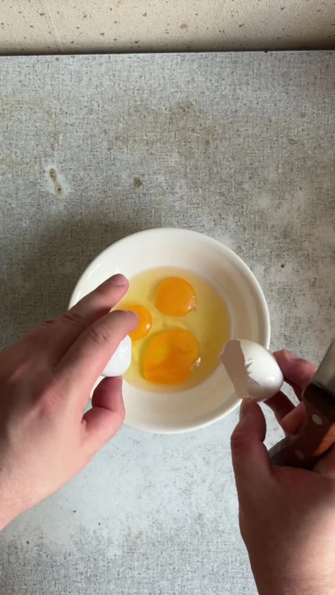 Vertical 4K video. Top view. Man with knife breaks chicken egg at kitchen Stock Footage 281795016