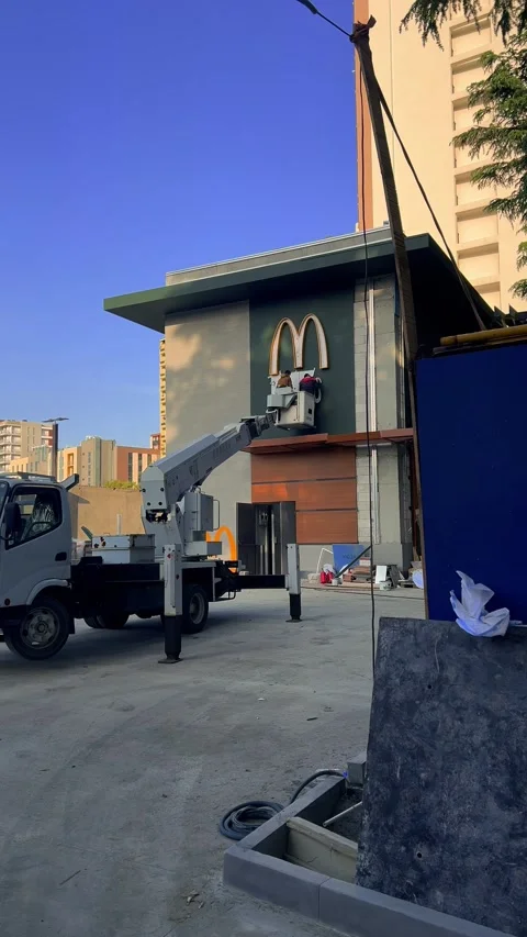 Vertical 4K video. Workers hang logo of fast food restaurant McDonald Stock Footage 309964428