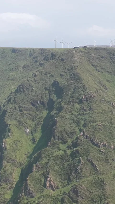 Vertical 9:16 aerial video showcasing the dramatic green cliffs and rugged Stock Footage 346662655