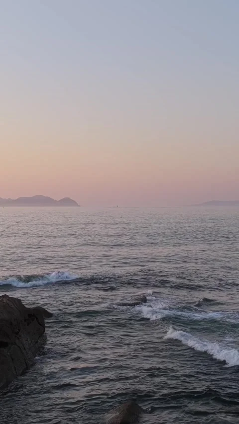 Vertical 9:16 video showing the Atlantic Ocean along the rocky coast of Baiona Stock Footage 346663046
