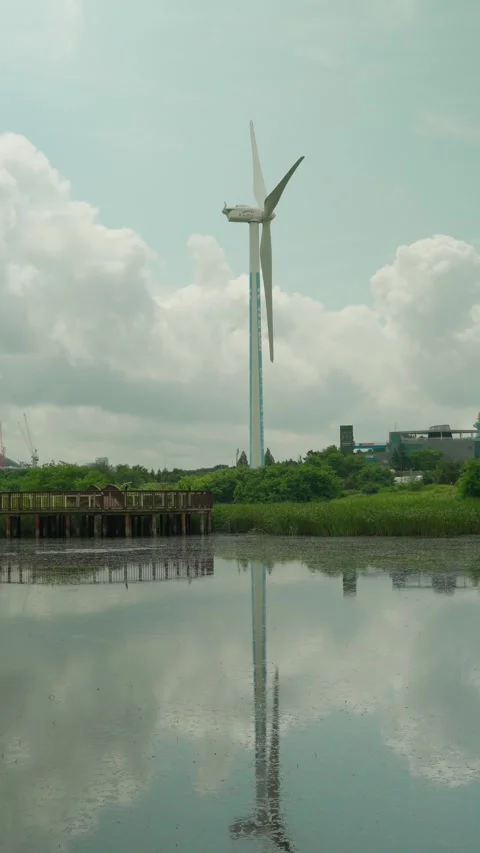 Vertical 9x16 Wind Turbine Generator Over Lake Park Stock-Footage 340459377