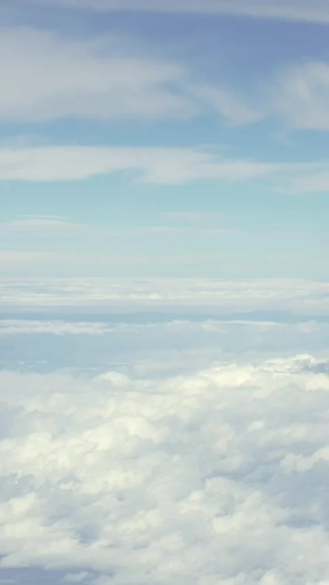 Vertical Above clouds, airplane reveals a serene skyscape, during flight travel Stock Footage 307571636