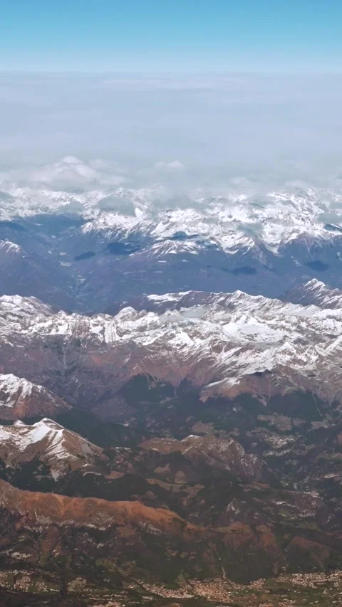 Vertical Above peaks a clouds covers sky, snow capped Alps rugged mountain peaks Stock Footage 314233928