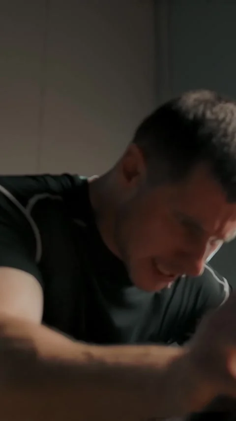 Vertical of An active man athlete pedalling on a stationary bike in a gym Stock Footage 276922505