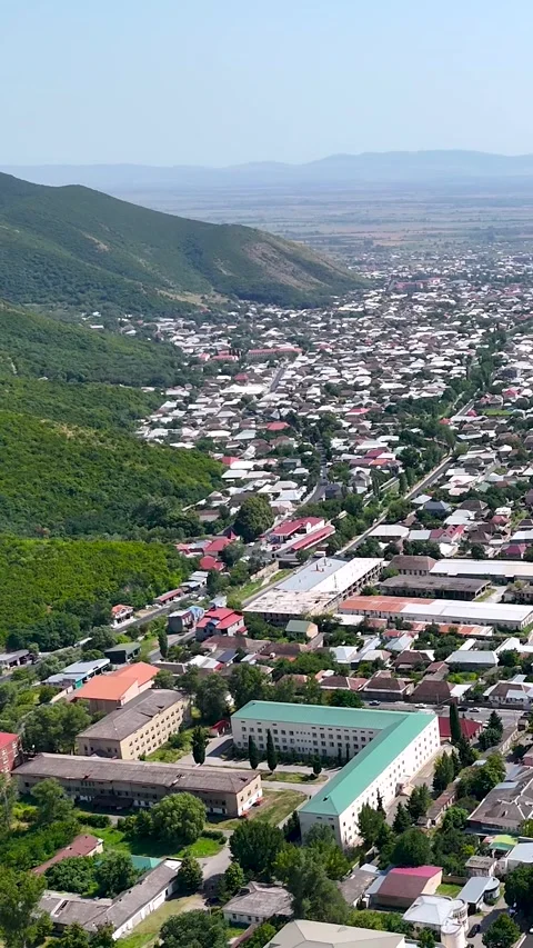 Vertical aerial 4K view of Sheki city surrounded by Caucasus mountains Stock Footage 341337308